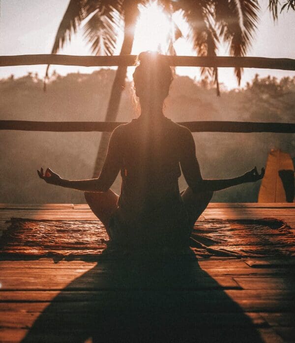 A person sitting in the middle of a yoga pose.